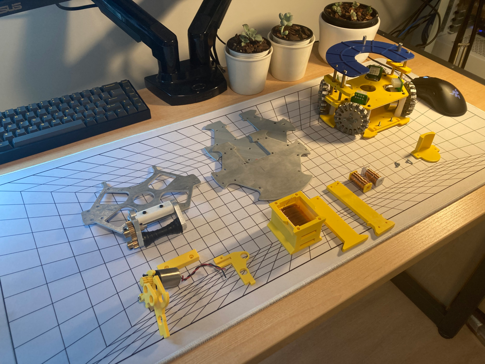 Robot soccer prototype disassembled into printed and machined parts